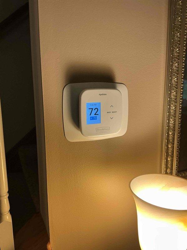 Responded to customer complaint of continuous alarm following recent A/C installation. Removed newly installed Aprilaire thermostat and associated mounting plate with contractor branding from wall. Reinstalled customer's original thermostat per homeowner request, resolving alarm issue and restoring system to normal operation.