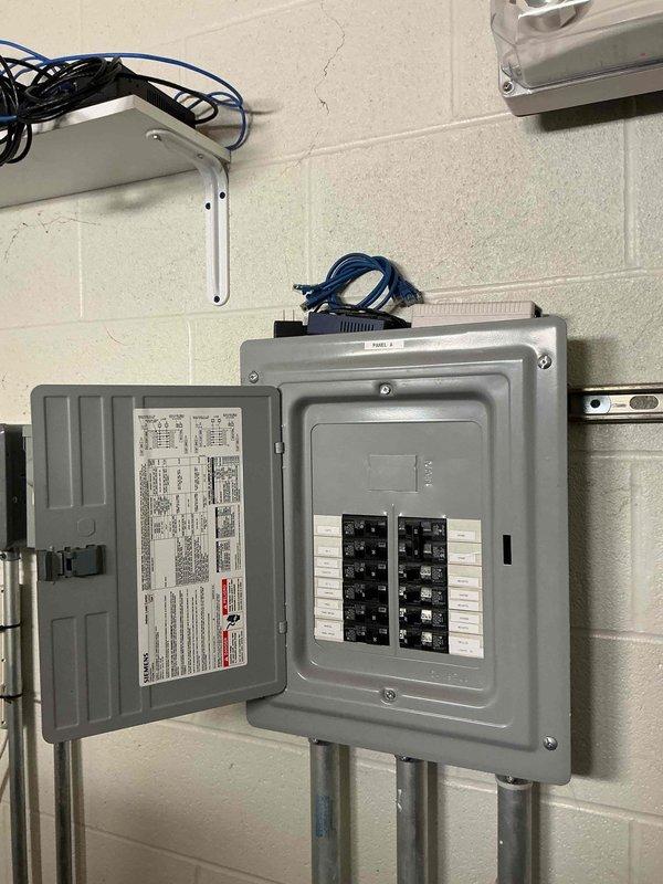 Met with facility representative to assess electrical requirements for restroom heating installation at service department facility. Conducted site inspection of existing electrical infrastructure, including main panel and available circuits, to determine capacity and routing options for proposed electric heaters. Documented current electrical panel configuration and mechanical space conditions with photographs to prepare accurate estimate for restroom heater installation project.