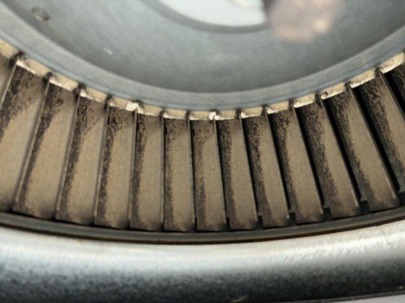 Completed routine cooling maintenance on 15-year-old air conditioning system. Inspected blower wheel assembly and noted significant dust accumulation on fan blades requiring cleaning attention. Observed extensive rust and corrosion on circular metal component within fan guard assembly, indicating advanced deterioration that may require future replacement to prevent system failure.