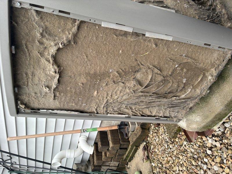 Completed comprehensive tune-up on aging air conditioning system with significant dust and debris accumulation on condenser coils and interior components. Cleaned condenser unit, addressed deteriorated cabinet insulation showing wear and compression damage, and performed standard maintenance procedures to restore system efficiency.