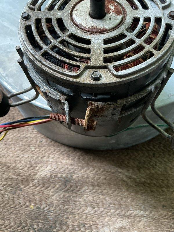 Replaced failed blower motor, capacitor, and circuit board on outdoor HVAC unit located in exterior closet. The original blower motor exhibited severe corrosion on terminal connections and housing, indicating moisture exposure and component failure. Removed deteriorated motor assembly and installed new blower motor with proper electrical connections. Replaced failed capacitor and circuit board to restore system functionality. Work was coordinated for dry weather conditions to protect exposed components during repair. All electrical connections were secured and tested for proper operation upon completion.