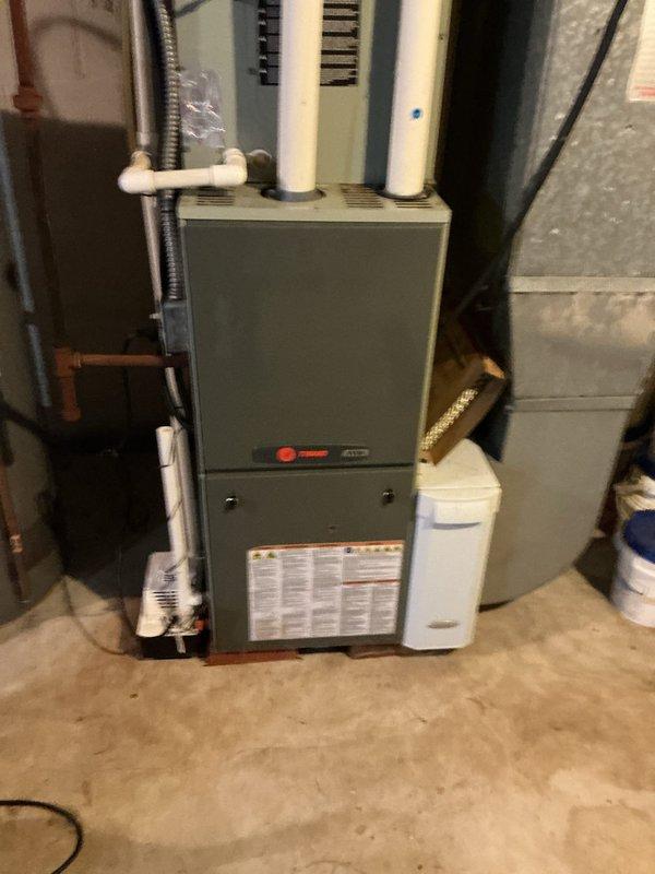 Responded to customer complaint of clicking noise from A/C system in basement that persisted even when unit was not running. Upon inspection, traced noise to a faulty relay or contactor component in the HVAC system. Inspected Trane furnace unit and associated equipment, examined electrical connections and control components to identify source of intermittent clicking. Determined the clicking was originating from a defective control component that was cycling improperly regardless of thermostat call status.