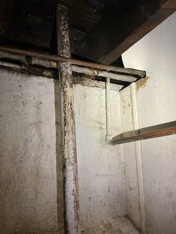 Responded to emergency call for burst pipe in basement. Upon arrival, found severely corroded vertical supply line with active leak that had forced customer to shut off main water supply to entire residence. Pipe showed extensive rust deterioration and surface degradation throughout its length, indicating long-term corrosion damage that ultimately resulted in failure. Documented existing conditions with photographs showing the compromised piping, aging infrastructure, and moisture damage to surrounding concrete walls. The affected area displayed typical characteristics of an older utility space with significant staining and discoloration from water exposure.
