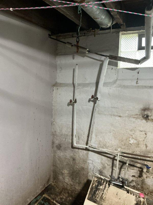 Responded to emergency call for burst pipe in basement. Upon arrival, found severely corroded vertical supply line with active leak that had forced customer to shut off main water supply to entire residence. Pipe showed extensive rust deterioration and surface degradation throughout its length, indicating long-term corrosion damage that ultimately resulted in failure. Documented existing conditions with photographs showing the compromised piping, aging infrastructure, and moisture damage to surrounding concrete walls. The affected area displayed typical characteristics of an older utility space with significant staining and discoloration from water exposure.