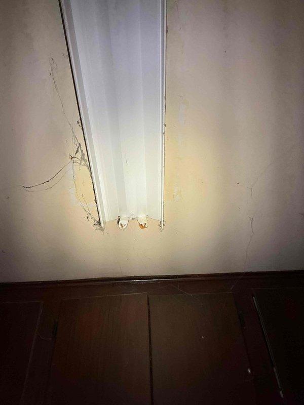 Responded to service call for broken fluorescent socket in laundry room of 40+ year old home where socket failure occurred during bulb replacement attempt. Upon arrival, inspected fluorescent fixture mounted in corner near ceiling, documented existing condition showing signs of age and wear on surrounding surfaces. Verified membership status and applicable service plan coverage prior to proceeding with work. Evaluated socket integrity and determined whether socket replacement alone would suffice or if complete fixture replacement was necessary due to age-related deterioration of internal components. Photographed fixture in both illuminated and detailed views to document pre-existing conditions and justify repair recommendations. Completed necessary repairs to restore proper lighting function in laundry room area.