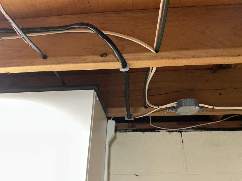 Installed a dedicated 50-amp, 240-volt circuit for Tesla electric vehicle charger. Removed existing breaker from electrical panel to accommodate new two-pole 50-amp breaker. Ran 6-3 Romex wire through basement to garage area and terminated at disconnect switch mounted on garage joist. Installed three-quarter inch PVC conduit from disconnect across garage ledge to charger mounting location. Pulled #6 THHN conductors through conduit and completed installation of Tesla wall charger at requested joist-mounted position, ensuring all connections met NEC requirements for EV charging equipment.