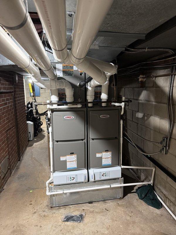 Completed installation of air conditioning system with two evaporator coils serving dual Lennox furnace units in basement mechanical room. Replaced worn FLNR 50 amp time-delay fuses to ensure proper electrical protection for the new equipment, with old fuses showing significant oxidation and tarnishing that could have compromised system safety and performance.