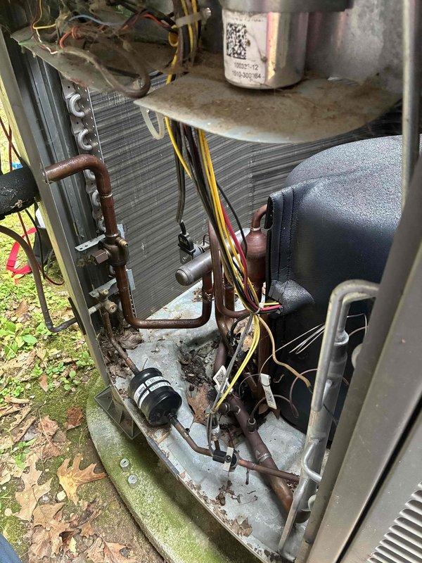 # HVAC Cooling System Maintenance Completed

Performed comprehensive spring tune-up and preventive maintenance on outdoor air conditioning unit as part of routine membership service. Upon arrival, contacted customer via provided phone number while en route to confirm appointment.

## Visual Inspection and Assessment

Conducted thorough visual inspection of outdoor condensing unit with access panels removed. Unit displayed signs of extended service life with notable weathering and oxidation on copper refrigerant lines showing brown patination. Heat exchanger coil fins were intact but accumulated with dust and debris. Compressor showed surface weathering consistent with outdoor exposure. Internal base platform contained dirt accumulation and staining from environmental exposure.

## Condenser Coil Condition

Identified significant contamination on condenser fin panel requiring attention. Heavy accumulation of dust, dirt, lint, and organic debris was present throughout fin surfaces, with 