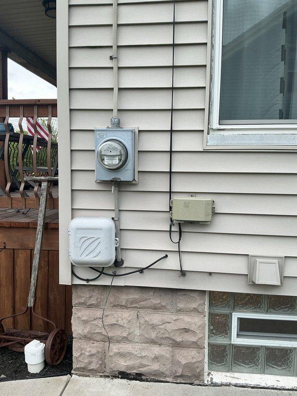 Completed electrical panel replacement at residential property in preparation for fall season. Installed new circuit breaker panels to replace outdated equipment, ensuring proper load distribution and code compliance. Exterior meter base and junction box connections verified and secured with appropriate conduit routing along building siding. Interior basement installation included mounting dual panel configuration on concrete block wall with organized circuit breaker arrangement. All electrical connections tested and confirmed operational, improving overall system safety and reliability for the residence.