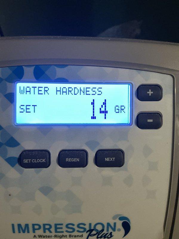 Delivered salt supply to service location for Water-Right Impression Plus water softening system. Retrieved salt from warehouse inventory and transported to site. System operational at time of delivery, with digital control panel displaying water hardness setting of 14 grains and total gallons processed at 300,127.