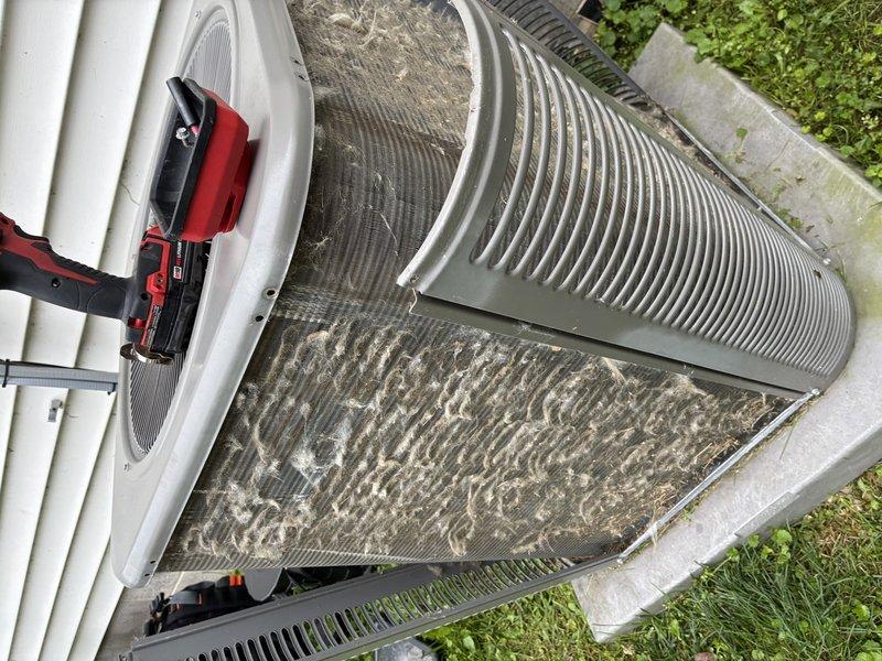 # HVAC Maintenance - Cooling

Completed routine MVP cooling maintenance visit on a 6-year-old residential air conditioning system. Upon arrival, performed comprehensive inspection of outdoor condenser unit, which revealed heavy accumulation of dirt, dust, and debris throughout the condenser coil fins and filter surfaces. The buildup showed significant grayish-tan coating with streaked patterns indicating extended period between services, along with darker discoloration and clumping between fin spaces.

Conducted thorough cleaning of condenser coil fins to remove accumulated debris and restore proper airflow through the unit. Cleaned filter surfaces that displayed considerable particulate matter accumulation affecting system efficiency. Verified condenser fan operation and inspected cylindrical fan housing with ventilation grilles for proper function. Performed diagnostic measurements using electronic testing equipment to assess system performance parameters.

Inspected unit cabinet and