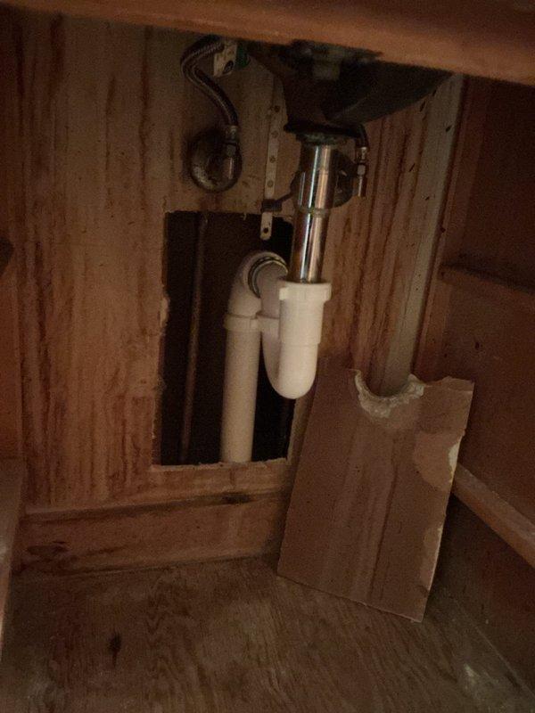 Removed and replaced deteriorated galvanized drain line from the main stack tie-in to the kitchen sink drain. Work required accessing plumbing through the back of the cabinet, which was opened to facilitate the repair. Installed new drainage piping to restore proper function and eliminate leaks in the drain system. Cabinet and drywall restoration is the responsibility of the homeowner. Additionally, toilet was reset; however, due to compromised subfloor conditions, no warranty can be provided for the toilet installation.