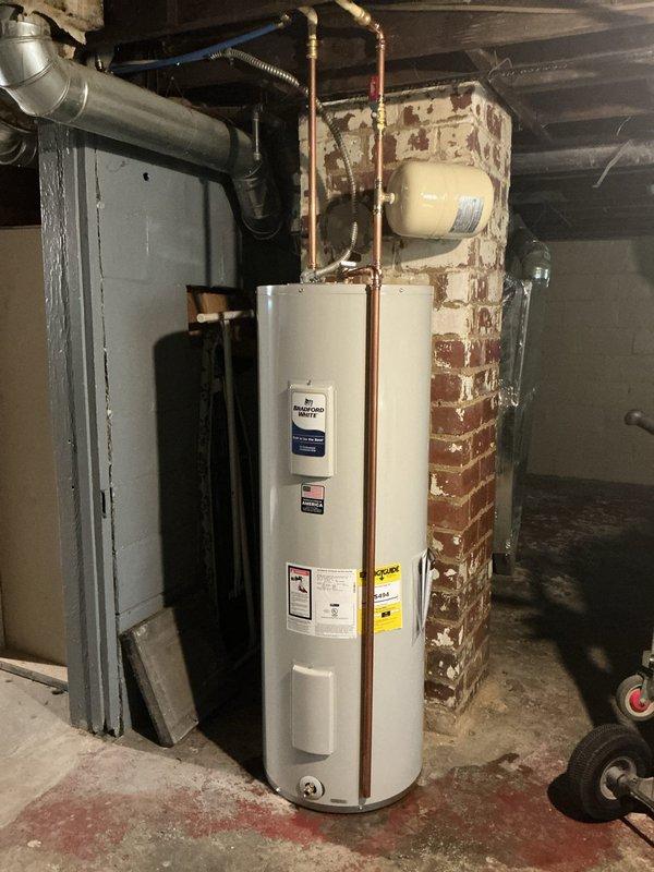 Replaced illegally installed 40-gallon gas water heater that had been red-tagged by the gas company with a new Bradford White 50-gallon electric water heater with 6-year manufacturer warranty. Removed existing CPVC shut-off valves and installed transition couplings above the water heater to connect from CPVC to copper piping. Installed new cold water shut-off valve, expansion tank, and drip leg on the temperature and pressure relief valve. Patched the existing chimney opening where the previous gas water heater vented and capped off the gas line to complete the conversion from gas to electric operation.