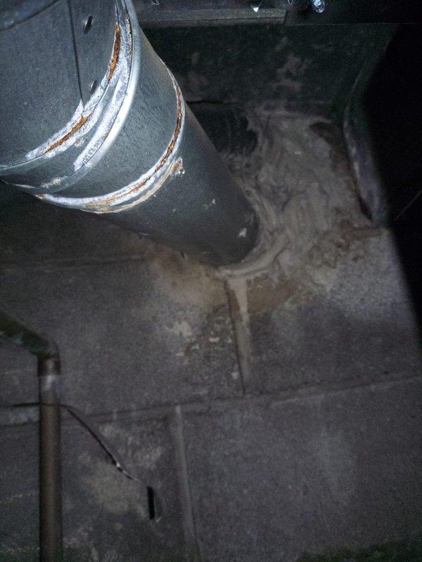 Completed ductwork reconnection and chimney patch repair in crawlspace area. Addressed compromised duct connections showing corrosion at metal band joints and reinstalled horizontal rectangular supply duct between floor joists. Secured all ductwork connections to ensure proper airflow and system efficiency while noting surrounding structural wood damage from insect activity for homeowner awareness.