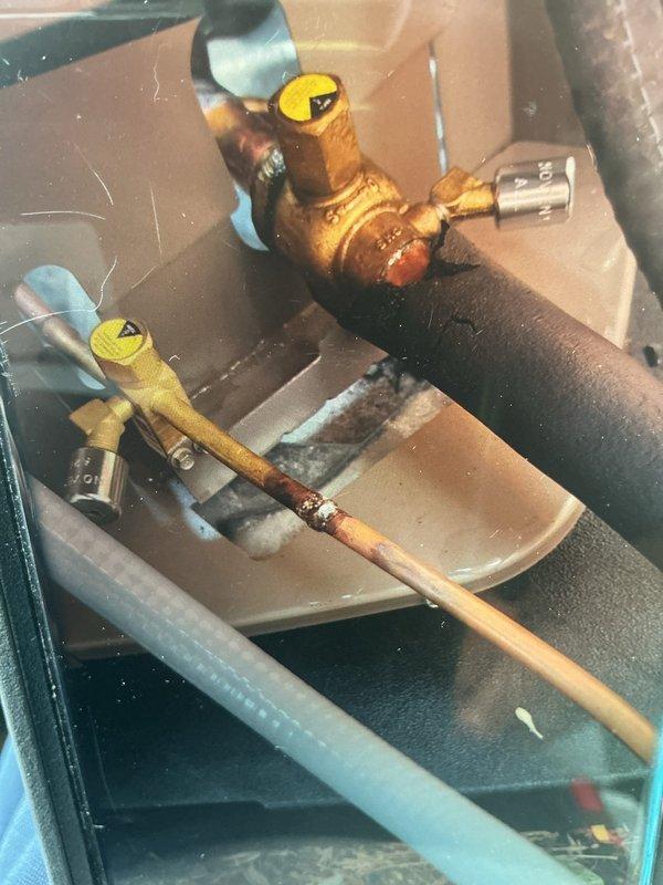 Responded to failed inspection for missing tamper cap on HVAC installation. Inspected copper refrigerant line set with brass ball valves and exterior disconnect box, verified tamper cap was not properly threaded during initial installation. Reinstalled and secured tamper cap to manufacturer specifications to bring system into compliance with code requirements.