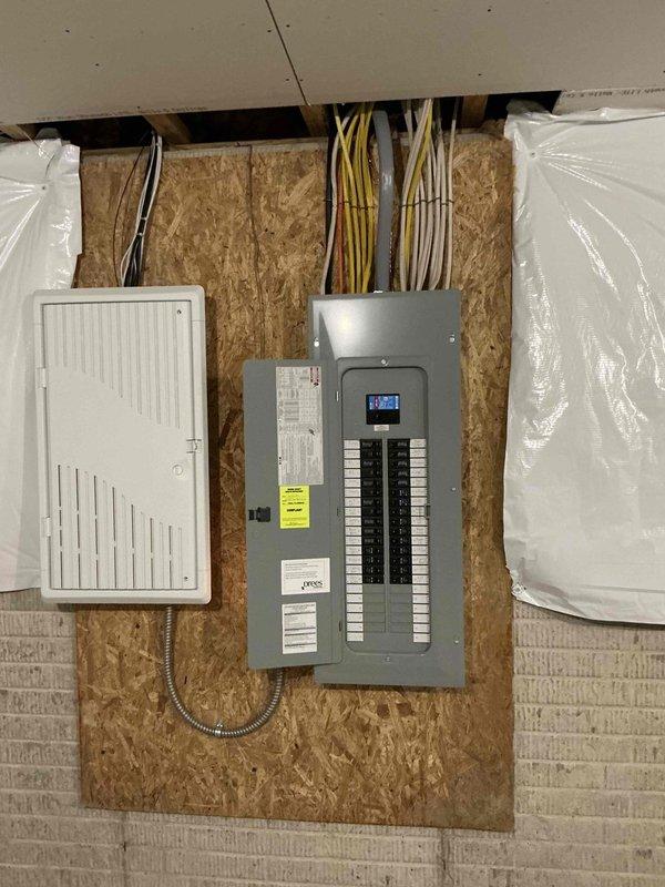 Conducted on-site evaluation for whole-house generator installation. Assessed existing electrical infrastructure including main service panel with dual-column breaker configuration serving multiple dedicated circuits for major appliances, HVAC systems, and general branch circuits. Documented current panel capacity and circuit distribution to determine proper sizing requirements for automatic transfer switch integration. Photographed secondary electrical panel installation on OSB backing, noting existing digital monitoring system and telecommunications equipment that will require coordination during generator interconnection. Evaluated wire routing pathways and conduit access points for transfer switch installation. Provided comprehensive documentation of electrical system layout to develop accurate material list and labor estimate for generator installation project.
