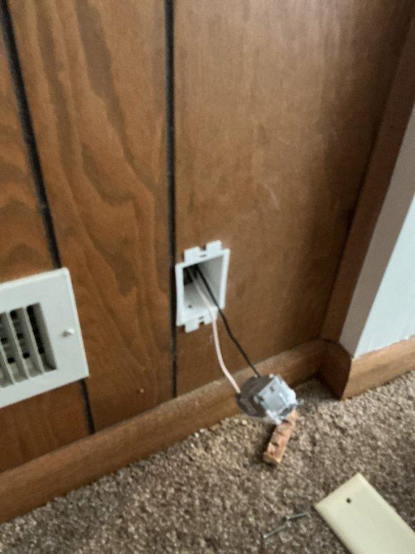 Installed spark guard protection device on existing 2-wire electrical system where GFCI installation was not feasible. Trimmed wood paneling to access junction box and secured device with 3-inch screws to properly reach the recessed electrical box. Completed low-voltage cable outlet installation and organized wiring routing along wall and carpet transition.
