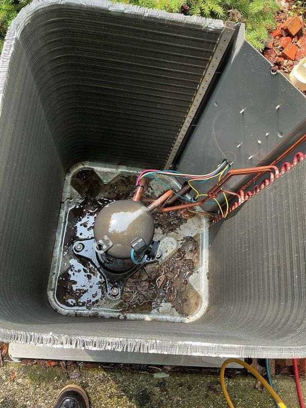 Completed MVP cooling maintenance visit on 9-year-old system. Inspected Aprilaire thermostat confirming proper operation and display functionality. Serviced outdoor condensing unit, noting significant debris accumulation in base pan with standing water and corrosion on internal components requiring attention for optimal system performance.