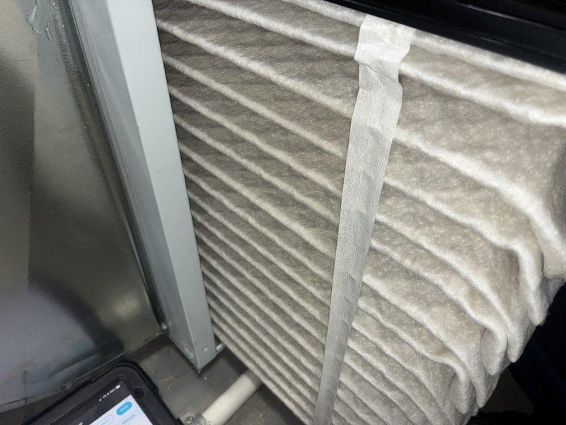 Completed preventive maintenance cooling visit on HVAC system. Inspected and photographed air filtration system showing pleated filters in proper working condition within mechanical space housing. Examined outdoor condenser unit coil, which displayed moderate accumulation of debris and surface contamination requiring attention for optimal heat transfer efficiency.