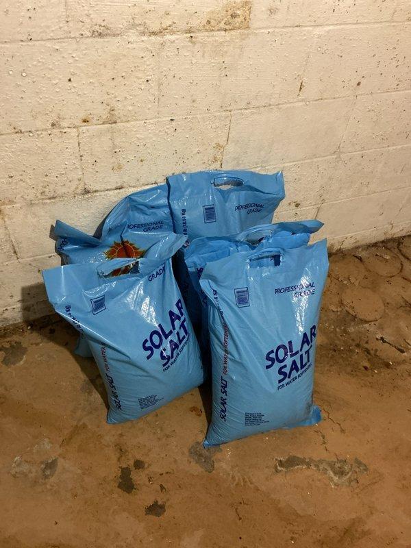 Completed recurring water softener salt delivery service. Retrieved three bags of professional-grade solar salt from warehouse inventory and delivered to property. Replenished existing salt storage system, filling the brine tank with granular salt to ensure continued operation of the water softening equipment.