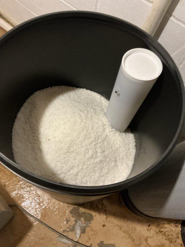 Completed recurring water softener salt delivery service. Retrieved three bags of professional-grade solar salt from warehouse inventory and delivered to property. Replenished existing salt storage system, filling the brine tank with granular salt to ensure continued operation of the water softening equipment.