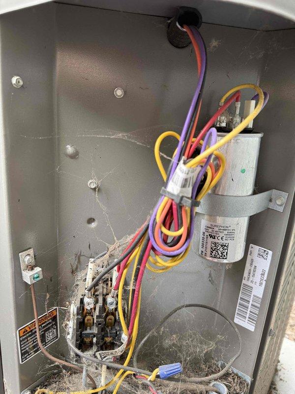 Completed BS-MVP recurring cooling maintenance visit on HVAC system. Performed comprehensive inspection of unit interior, including electronic control board, wiring connections, capacitor, and refrigeration components. Documented system condition with interior access panel removed, revealing complex PCB with multiple wire connections and terminal blocks. Observed dust accumulation on interior surfaces and minor corrosion on terminal connections, typical of normal system operation. All electrical connections verified secure, and control board components functioning within normal parameters.