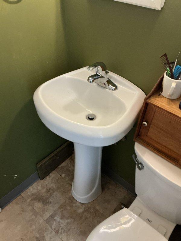 Installed two customer-supplied lavatory faucets at the property. The first-floor pedestal sink installation included replacing supply lines while retaining existing functional shut-off valves and reusing portions of the 1-1/4" trap assembly to avoid drywall removal for wall-concealed connections. The second-floor vanity installation required replacement of shut-off valves and supply lines, along with installing a new 1-1/2" PVC male adapter and reconfiguring the trap assembly to establish proper drainage connections.