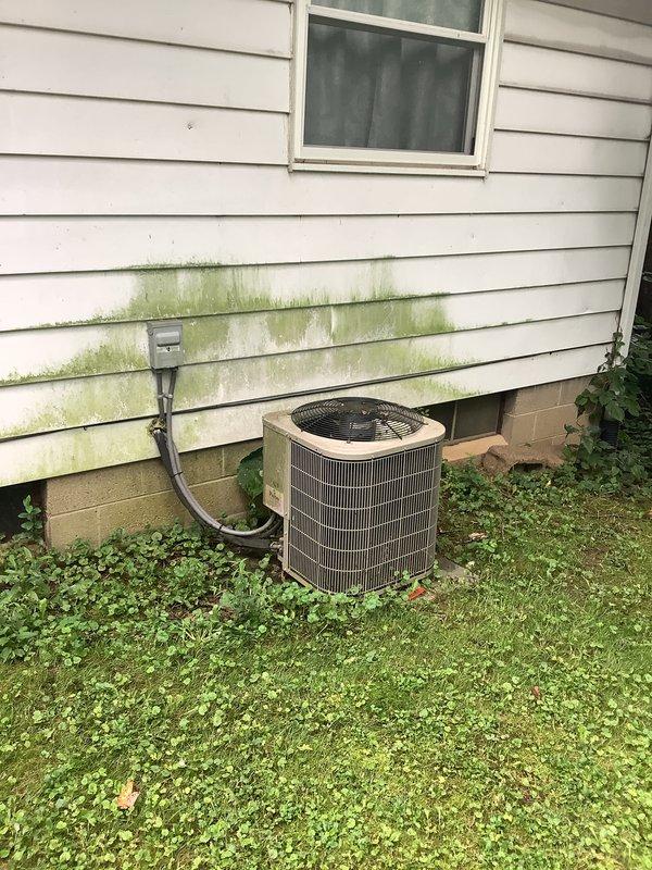 Conducted comprehensive assessment of existing HVAC system for complete furnace and air conditioning replacement estimate. Documented current outdoor condensing unit condition, noting aging cylindrical unit with beige top panel positioned at building exterior foundation. Evaluated indoor equipment in basement utility area, photographing existing system components and environmental conditions including concrete floor moisture indicators and efflorescence patterns. Provided detailed replacement recommendations and equipment specifications to address proactive system upgrade needs prior to equipment failure.