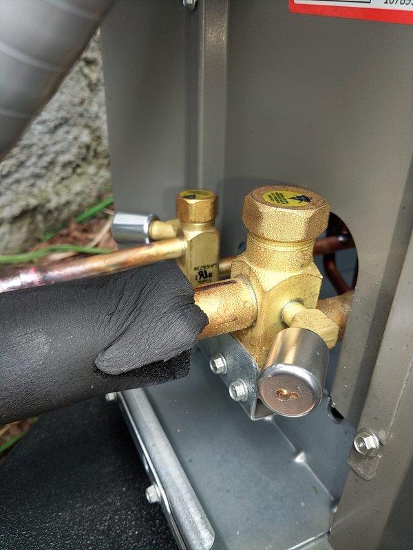 Completed full HVAC system installation including 80% efficiency furnace and air conditioning unit. Installed new Lennox furnace in basement mechanical room with all necessary ductwork connections, including metallic spiral duct transitions and proper ventilation routing. Configured PVC condensate drainage system and black plastic condensate lines with appropriate mounting brackets. Installed outdoor condensing unit with brass reversing valve assembly, copper refrigerant lines with compression fittings, and proper electrical connections including solenoid actuator. All components tested and verified operational. System commissioned and ready for service.