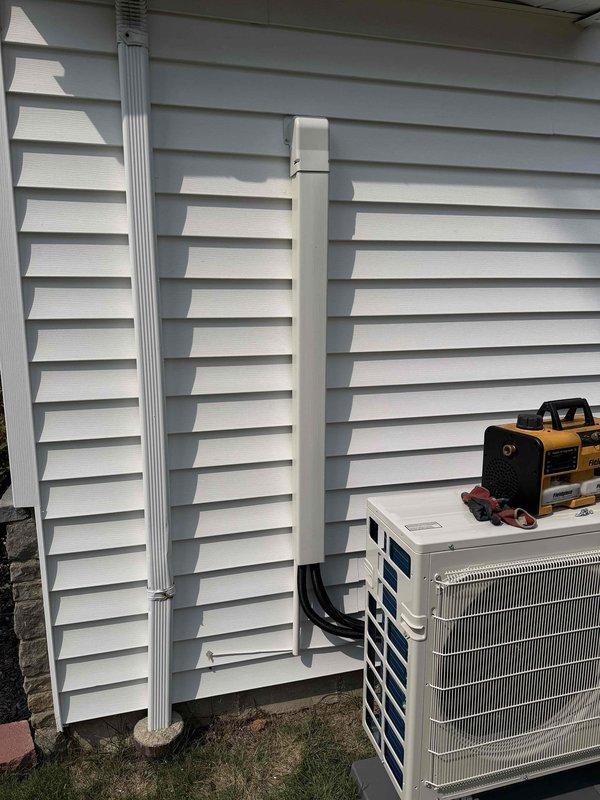 Completed installation of a Mitsubishi Electric 2-head mini split system, model MXZ-2D20NLHZ. Mounted outdoor condenser unit on exterior wall with proper leveling and secured to manufacturer specifications. Installed refrigerant line set with insulation, routed and secured lines vertically along building exterior using appropriate mounting brackets. Connected electrical supply via conduit with 20-amp breaker protection per unit requirements. Installed PVC condensate drain line with proper pitch for drainage. System charged with R410A refrigerant to manufacturer specifications. Verified all electrical connections, tested system operation in both heating and cooling modes, and confirmed proper airflow from both indoor heads. Installation meets all code requirements and manufacturer guidelines.