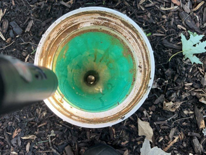 Responded to main drain backup with floor drain in basement experiencing sewage backup. Located and accessed basement floor drain with significant brown staining and buildup around perimeter indicating chronic drainage issues. Removed drain cover and performed main line cleanout through accessible cleanout point. Exterior cleanout pipe showed mineral deposits and discolored water present in line, confirming blockage in main sewer line. Successfully cleared obstruction and restored proper drainage flow through main line. Verified clearance by observing water flow at both interior floor drain and exterior cleanout access point.