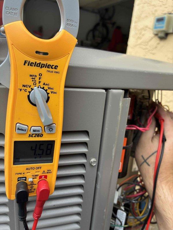 Completed routine cooling maintenance visit on 7-year-old air conditioning system. Performed comprehensive inspection of outdoor condenser unit, including electrical diagnostics using clamp meter which showed 4.90 amp draw. Accessed control panel to verify proper electrical connections and component operation, documenting system performance through photos for service records.