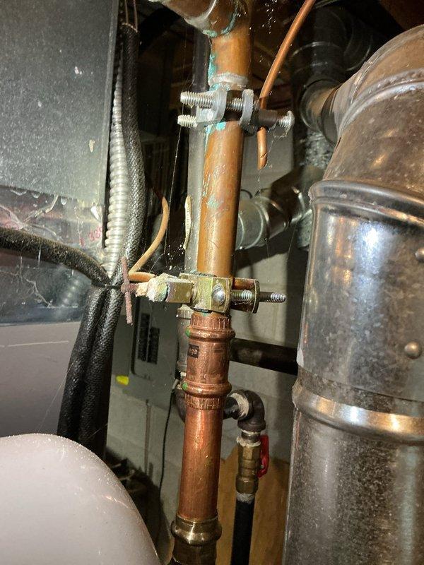 Responded to service call for water leaking from bottom of natural gas water heater. Upon inspection, identified Bradford White model RG240T6N 40-gallon automatic storage water heater with active leak at base of tank. Documented existing conditions including corroded copper piping connections and aged mechanical components in utility space. Tank failure determined to be non-repairable due to internal corrosion causing bottom leak, requiring full unit replacement.