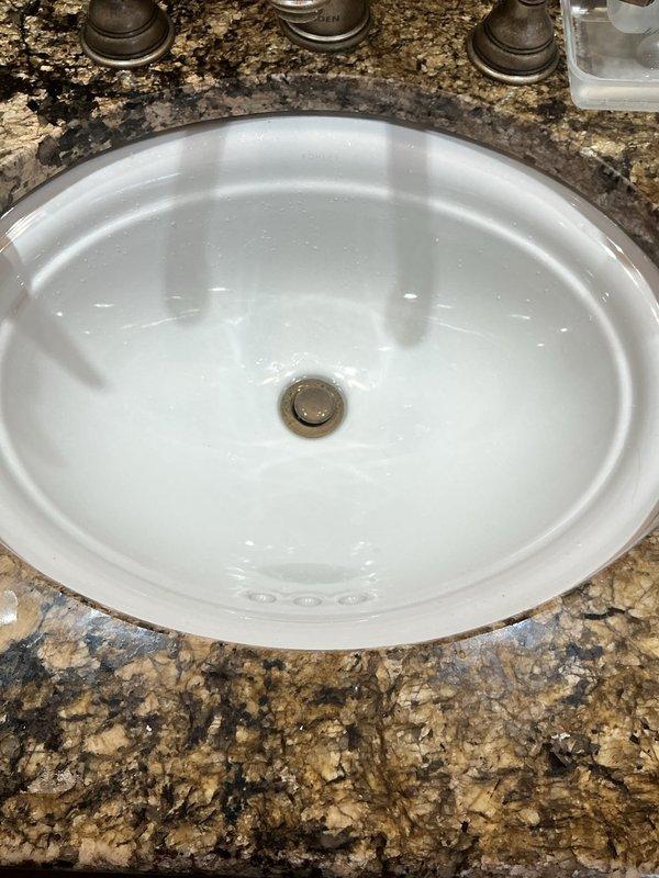Responded to utility room drain leak in a 32-year-old residential property. Upon inspection, accessed plumbing beneath sink and examined P-trap assembly and drain connections for source of reported leak. Verified proper drainage function, checked for loose fittings, and ensured all connections were secure and watertight.