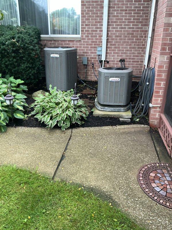 Completed MVP Cooling Visit recurring service maintenance on residential HVAC system. Performed comprehensive inspection of dual outdoor condensing units installed on exterior brick wall with concrete pad mounting. Verified proper operation of both heat pump units, inspected refrigerant line sets and electrical conduit connections running along building exterior. Checked SilverTech electrical disconnect box for secure mounting and proper weatherproofing. Confirmed all components functioning within normal parameters with no immediate service needs identified. System operational and ready for continued cooling season performance.
