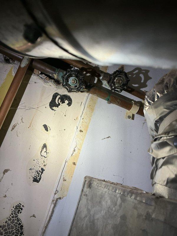 Responded to service call for pilot light failure on tanked water heater in 70-year-old residential property. Upon inspection of utility area, assessed aging copper supply lines, shutoff valves, and gas line connections showing significant oxidation and corrosion consistent with original installation. Diagnosed pilot assembly malfunction, cleaned thermocouple and pilot orifice, verified gas supply pressure, and successfully relit pilot light. Tested burner ignition sequence and confirmed proper operation of temperature/pressure relief valve and all safety controls before returning unit to service.