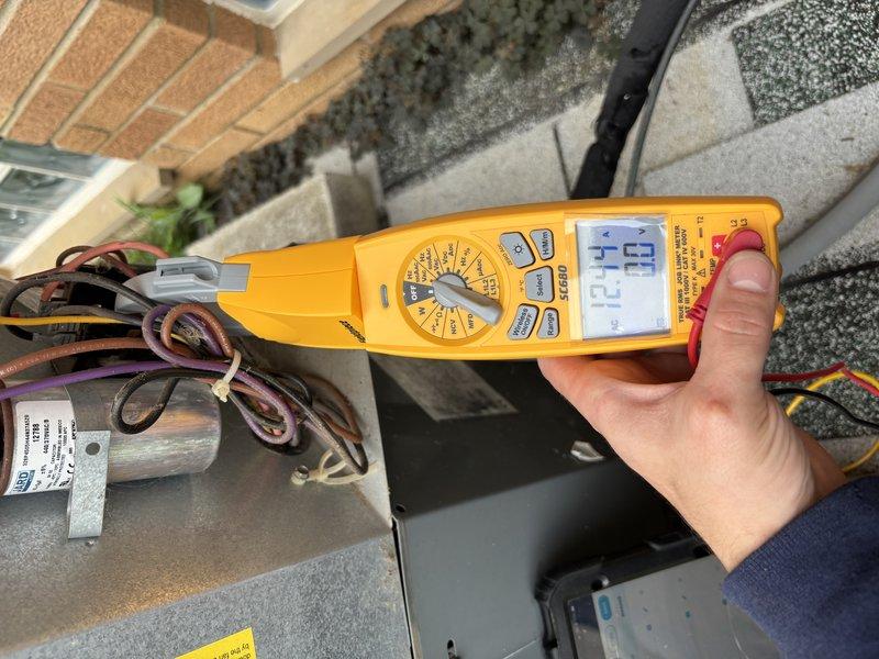 Performed comprehensive AC tune-up on 10-year-old cooling system with no reported issues. Conducted thorough inspection of evaporator coil, noting accumulated dust and debris on fins which was cleaned to restore optimal airflow and heat transfer efficiency. Tested electrical components using clamp meter, recording voltage at 122.6V and amperage at 69A, confirming system operating within normal parameters. Inspected capacitor, wiring connections, and mounting grommets, all showing proper condition with evidence of normal condensation. System tested and verified operational.