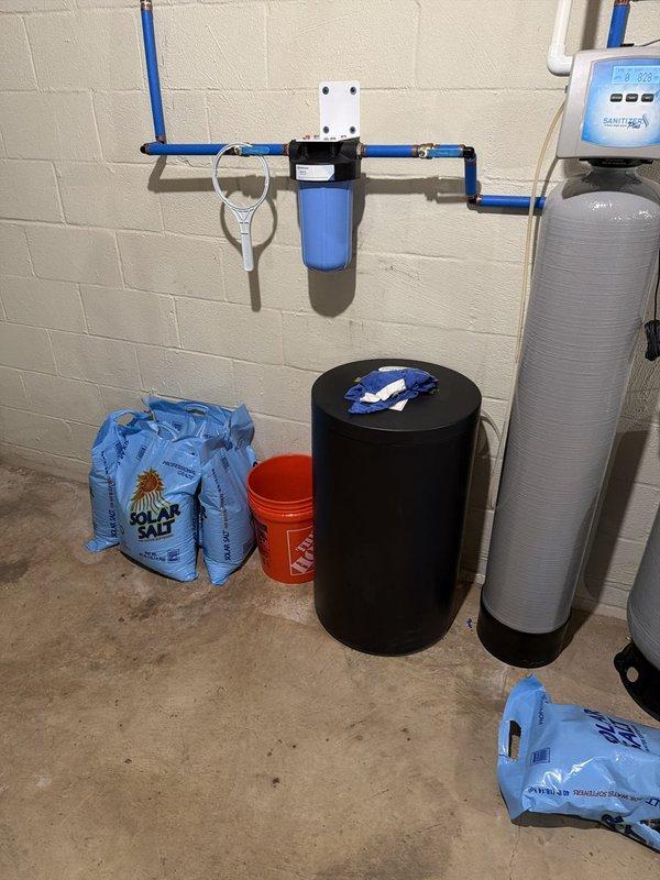 Delivered 5 bags of water softener salt to the property and restocked the supply for the residential water treatment system. Confirmed that the replacement filter previously ordered had been received at the shop and coordinated delivery to the plumber for installation on the wall-mounted filtration unit.