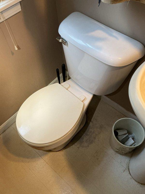 Responded to service call for toilet replacement on main floor. Upon arrival, inspected existing two-piece toilet with visible wear, discoloration, and rust staining on tank exterior. Assessed surrounding plumbing connections and water supply line for compatibility with new fixture installation. Removed old toilet unit by disconnecting water supply, draining tank and bowl, and unbolting from floor flange. Cleaned and inspected wax ring seal and closet flange for damage or deterioration. Installed new two-piece toilet with elongated bowl, ensuring proper alignment with floor flange and secure mounting. Applied new wax ring seal, connected water supply line with chrome shut-off valve, and tested for proper flush operation and leak-free connections. Verified adequate water flow and refill cycle. Caulked base perimeter to floor tile for stability and moisture protection. Conducted final inspection confirming fixture operates correctly with no leaks at supply connection or base seal. Left w