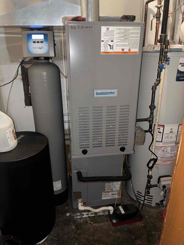 Completed MVP Cooling Visit maintenance on 3-year-old Comfortmaker HVAC system. Inspected electrical disconnect box exterior, verified pull-out disconnect switch operation, and confirmed fuse indicator lights functioning properly on Russell Tech component. Performed interior equipment inspection of air handler unit in basement utility area, documented system condition, and verified proper installation dating to May 2023. All components operating within normal parameters with no immediate service requirements identified.