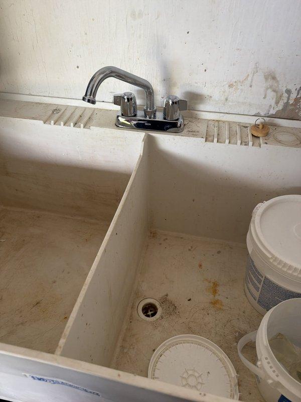 Responded to service call for utility sink faucet evaluation. Upon arrival, inspected double-basin laundry sink with chrome two-handle faucet assembly. Customer referenced previous diagnosis from April regarding faucet issue, though no prior work order or estimate was documented in system. Performed visual assessment of faucet installation, mounting hardware, and surrounding plumbing fixtures. Documented current condition of sink area and faucet assembly with photographs for service records.