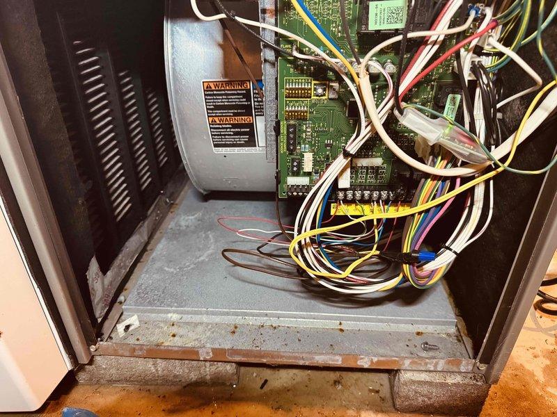 Responded to water leak concern in basement near HVAC system. Upon inspection, found standing water with sediment accumulation in condensate drain pan, indicating a drainage obstruction. Examined drain line connections and control board compartment for moisture damage. Cleared debris from drain pan, verified condensate pump operation, and confirmed air conditioning system was functioning properly at time of service. Recommended monitoring drain system for proper discharge to prevent future water accumulation.