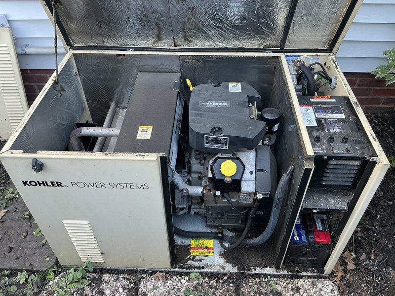 Responded to diagnostic call for 15-year-old Kohler generator experiencing abbreviated weekly exercise cycles, running only 30 seconds to 1 minute instead of the programmed 15-minute duration. Upon arrival, opened generator enclosure and performed visual inspection of internal components, engine assembly, and control panel. Inspected battery compartment revealing two batteries with visible corrosion, debris accumulation, and potential connection issues. Documented equipment condition through photographic evidence showing overall system layout, control interfaces, and battery configuration. Generator housing showed normal weathering for age with adequate ventilation maintained. Identified potential causes for shortened run cycle including battery voltage irregularities, control board programming drift, or exercise timer malfunction requiring further diagnostic testing or component replacement to restore proper weekly exercise function.