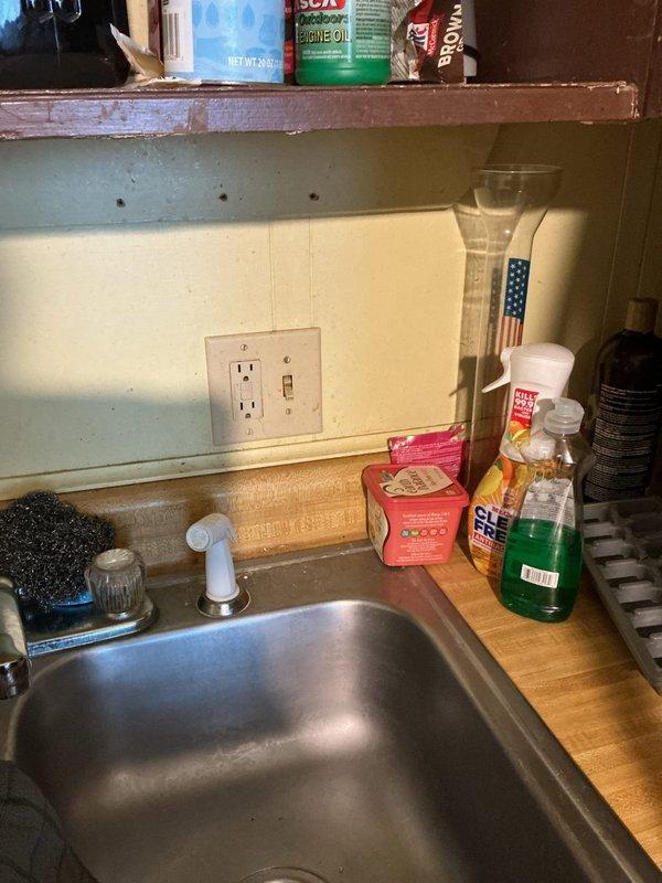 Responded to service call for non-functional electrical outlet with foreign object lodged in receptacle. Upon inspection, found debris obstructing outlet contact points at kitchen counter location. Safely removed lodged material from outlet, verified wiring integrity in accessible attic space above service area, and confirmed proper electrical connections at junction box. Tested outlet functionality post-repair and restored power to receptacle, ensuring safe operation for continued use.