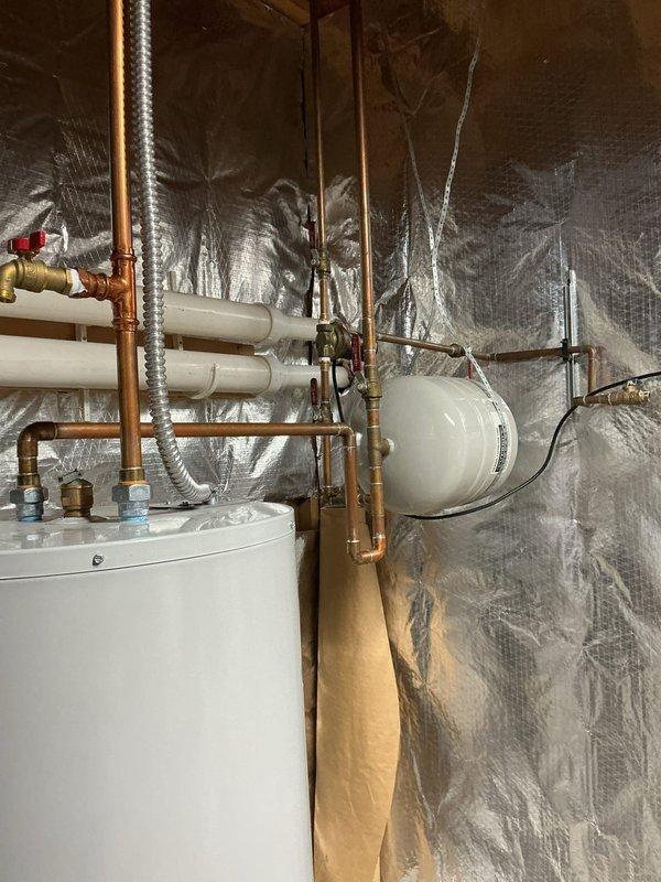Replaced residential tanked water heater system per customer request. Removed existing water heater and installed new unit with proper copper piping connections, pressure relief valve, expansion tank, and shut-off valves. Configured all plumbing connections to code specifications, secured PVC venting through exterior wall with appropriate mounting brackets, and verified system operation. All components tested and functioning properly upon completion.