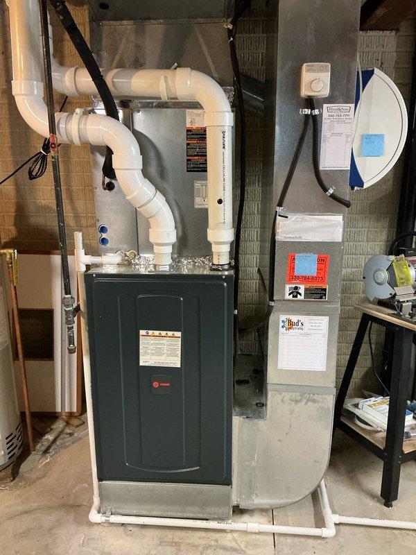 Completed MVP cooling maintenance visit on 6-year-old Trane furnace and Rheem air conditioning system that had been rescheduled from previous date. Performed comprehensive inspection of indoor furnace unit with heat exchanger and outdoor condensing unit, verified all components operating within normal parameters, checked refrigerant levels and electrical connections, inspected condensate drainage system and PVC venting, and documented system condition with photographs showing equipment in good working order with proper installation on concrete pad and adequate clearances maintained.