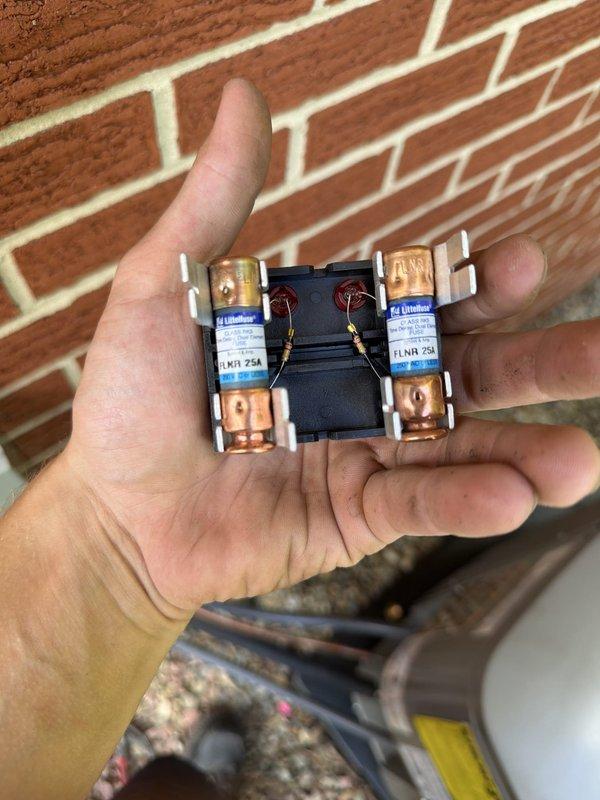 Completed installation of air conditioning system with evaporator coil as part of second-phase HVAC project. Installed outdoor condensing unit on rubber isolation pad with proper gravel base, mounted electrical disconnect box with FLNR 250 amp Littelfuse fuses, and ran refrigerant lines and electrical conduit along exterior brick wall. System tested and operational upon completion.