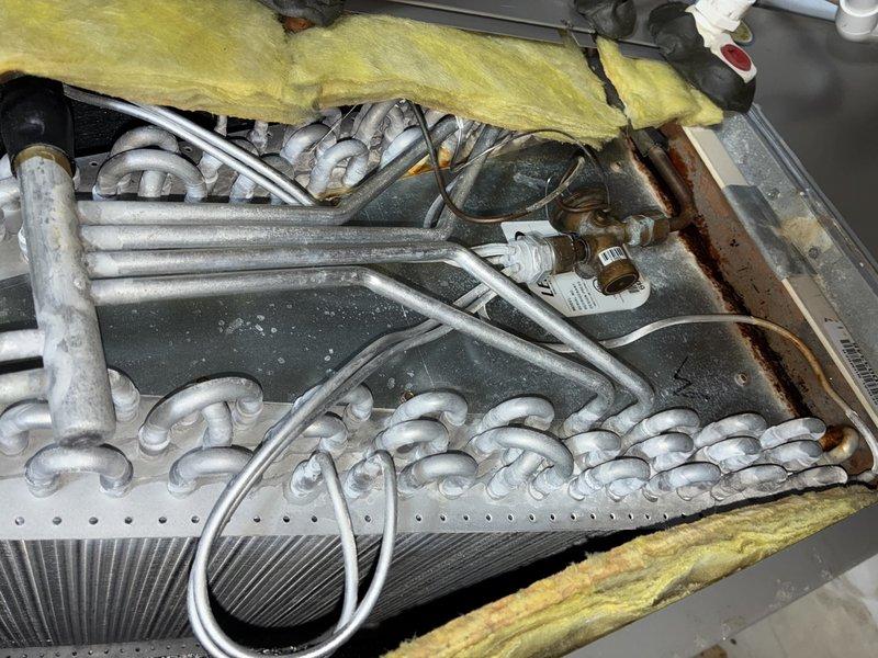 Responded to AC service call with customer reporting system issues but uncertain of specific symptoms or equipment age. Upon inspection, accessed control board compartment and heat exchanger assembly to perform diagnostic evaluation. Examined dual PCB control modules, wiring harnesses, relay connections, and terminal blocks for proper operation and secure connections. Inspected heat exchanger coils and refrigerant lines for condition and integrity. System components photographed for service records. Unit operational at time of departure.