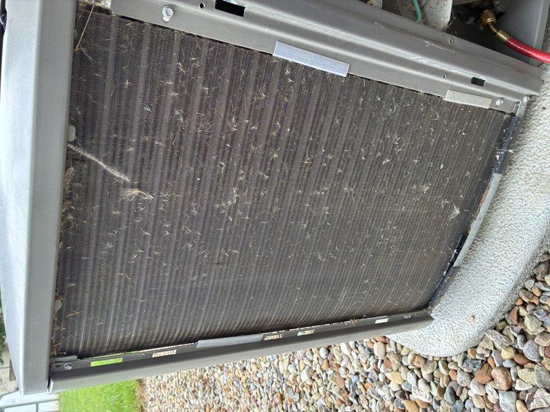 Completed MVP air conditioning maintenance on residential cooling system. Inspected condenser unit and documented heavy accumulation of dust and debris on coil fins, along with significant rust corrosion on blower motor assembly and mounting hardware. Noted green oxidation present on copper refrigerant lines indicating prolonged moisture exposure and aging equipment requiring attention.