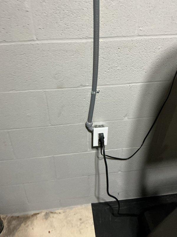 Responded to a GFCI tripping issue affecting a treadmill circuit in a basement workout area. The treadmill was previously installed on a shared GFCI-protected circuit with two other outlets. Upon investigation, determined that the treadmill's motor load was causing nuisance tripping of the GFCI device. Installed new dedicated circuit with surface-mounted EMT conduit and non-GFCI receptacle to isolate the treadmill from the existing GFCI-protected outlets, matching the configuration of the other two circuits in the space. Verified proper operation of all circuits and confirmed treadmill now functions without tripping issues.